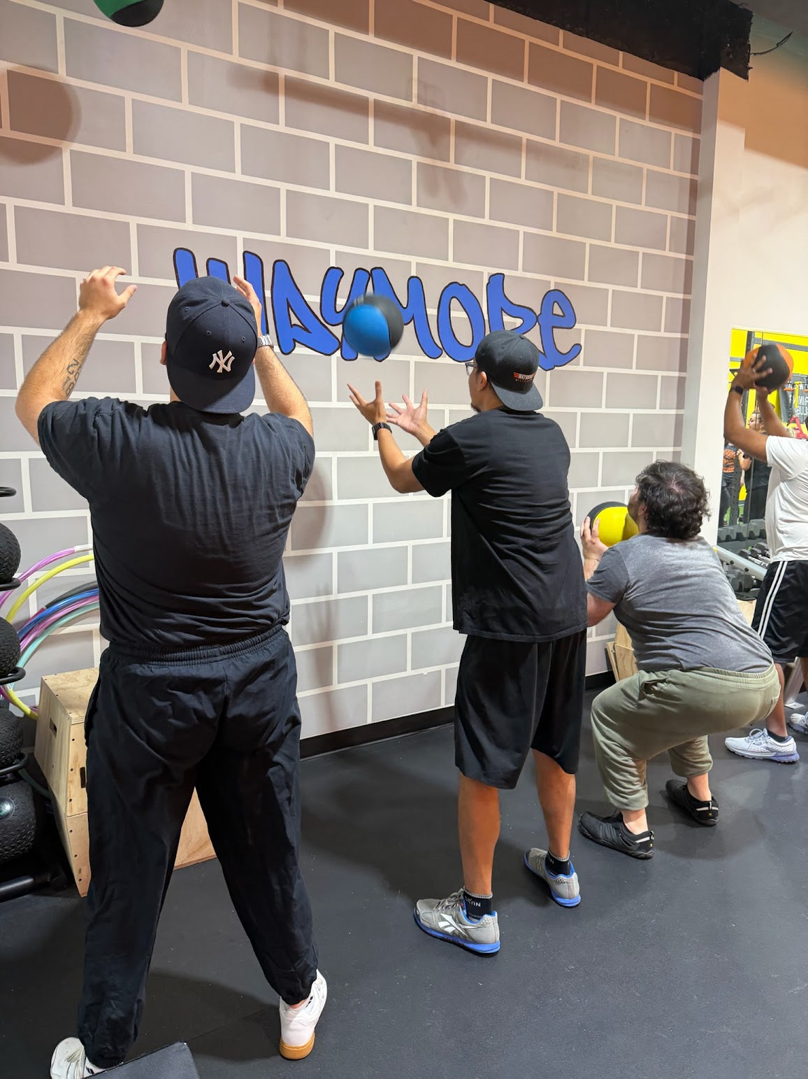 A new athlete pushing a sled in WayMore’s orange-wall gym — film-style campaign concept