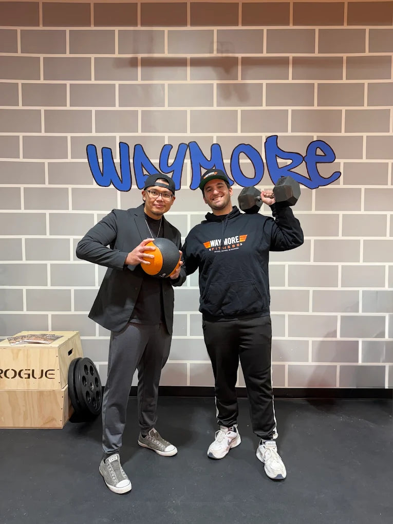 The WayMore team together beneath the gym’s WayMore wall sign